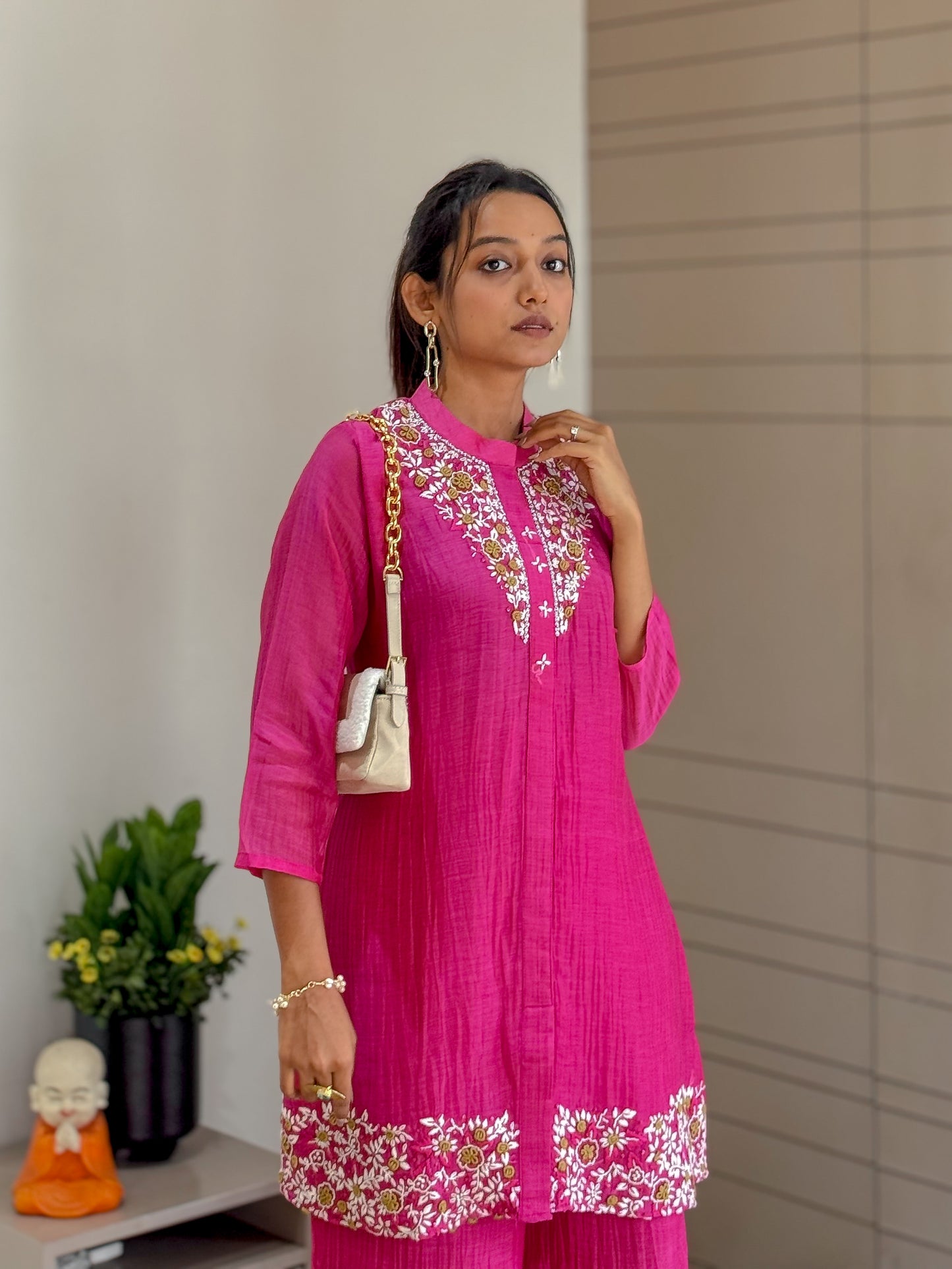 Woman pink Hand work outfit standing indoors with a neutral background