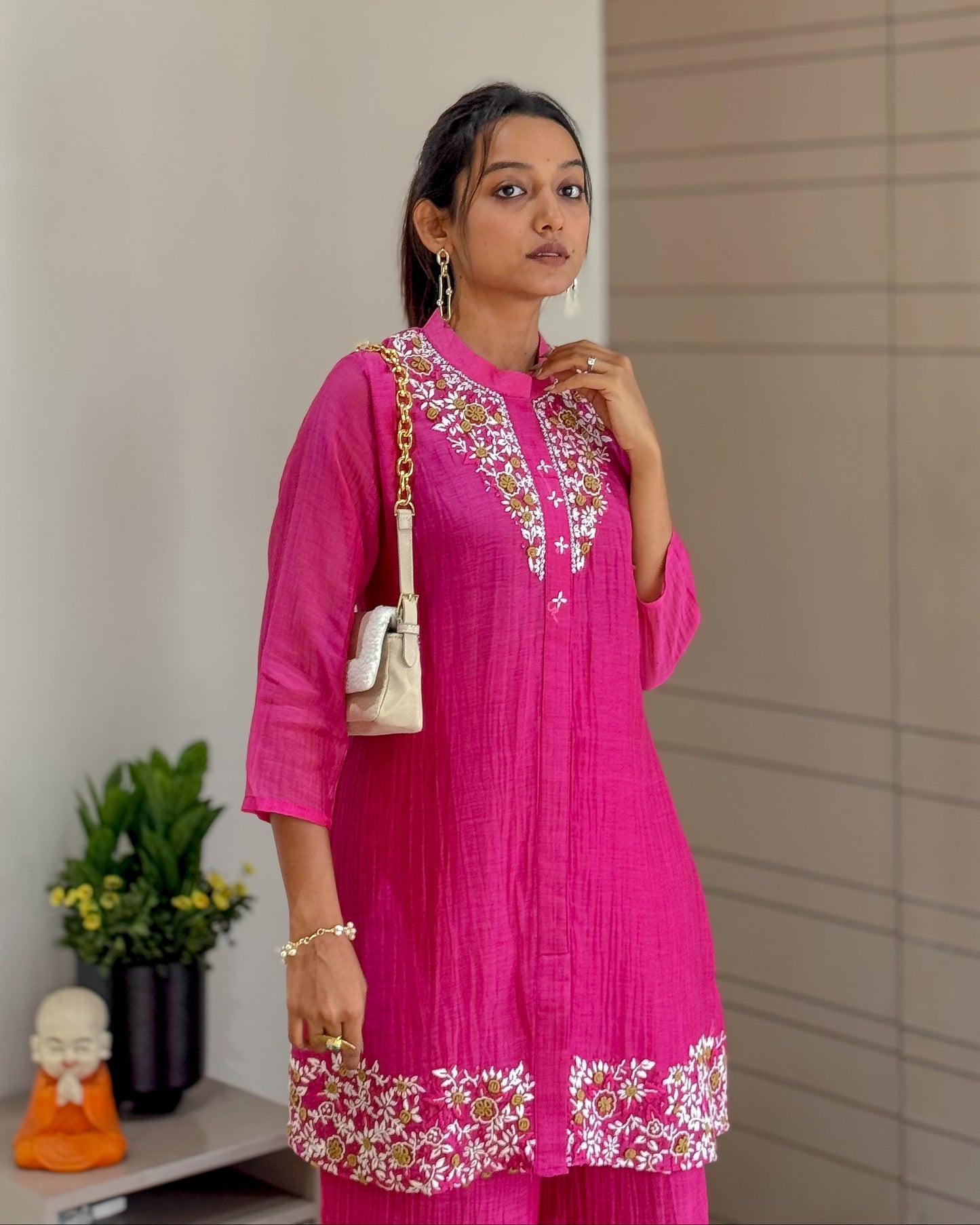 Woman pink Hand work outfit standing indoors with a neutral background