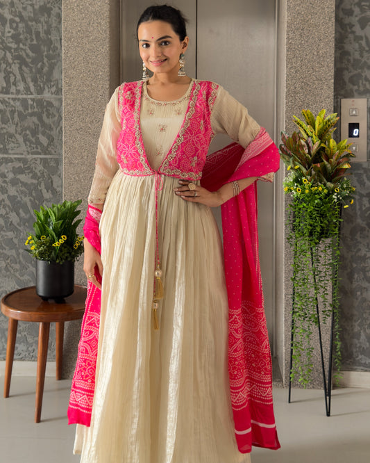 Woman in a traditional outfit with pink accents standing indoors.