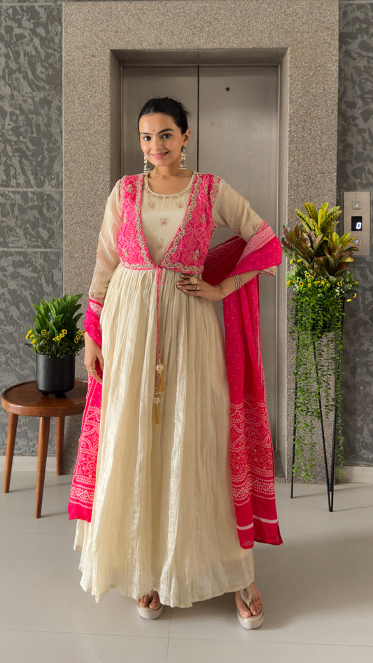 Woman in a traditional outfit with pink accents standing indoors.