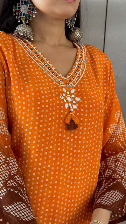 Orange traditional outfit with intricate embroidery and matching earrings.